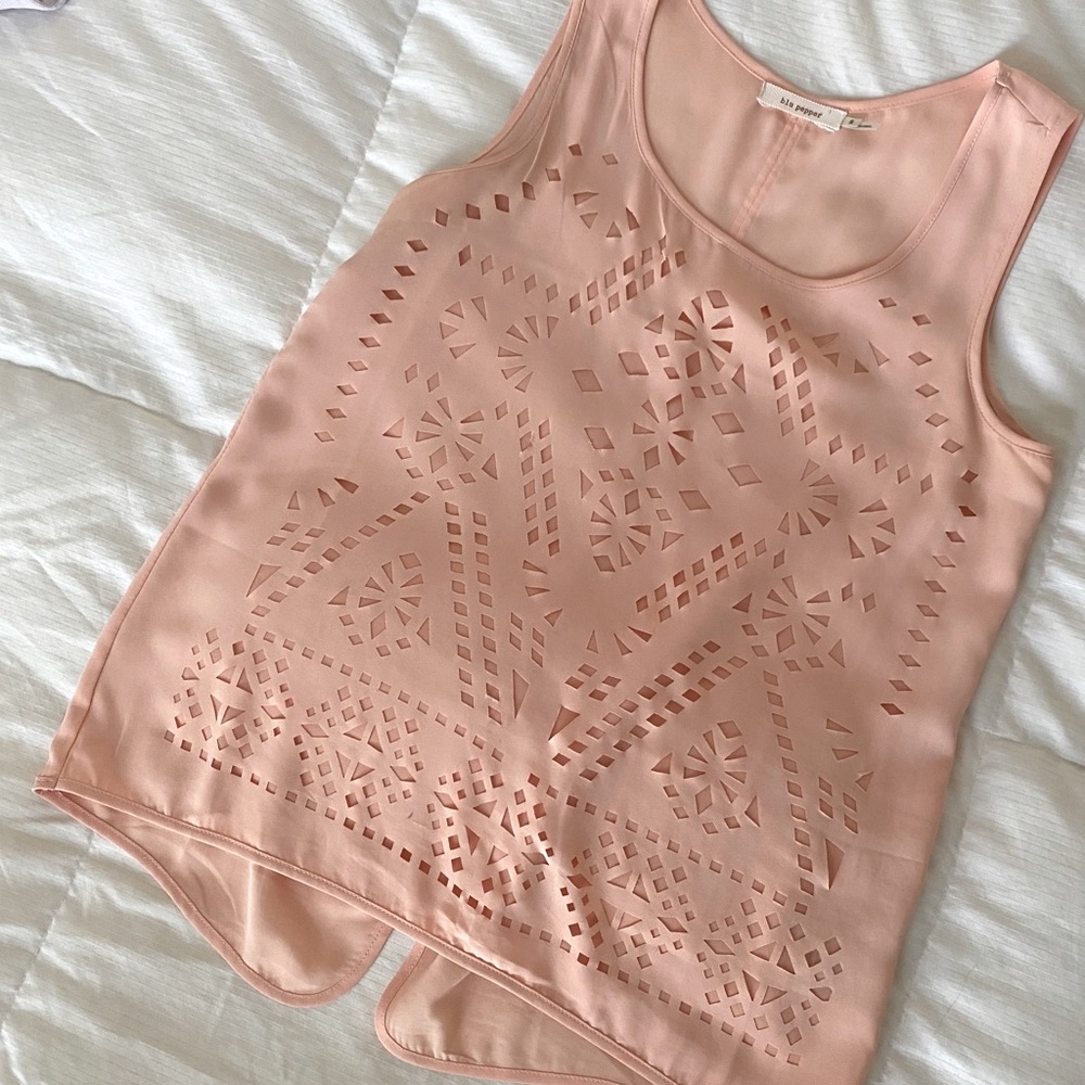peachy tank with geometric cut outs and silky feel